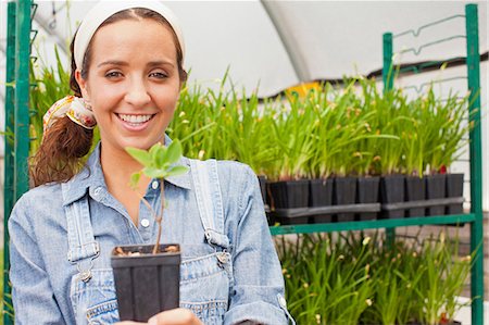 simsearch:614-06896204,k - Young woman holding plant in garden centre, portrait Stock Photo - Premium Royalty-Free, Code: 614-06896317