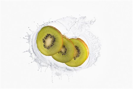 simsearch:614-06896427,k - Three slices of kiwi splashing in liquid Foto de stock - Sin royalties Premium, Código: 614-06896427