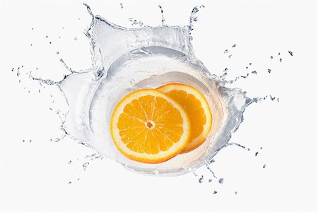 simsearch:614-06896427,k - Two slices of orange splashing in liquid Foto de stock - Sin royalties Premium, Código: 614-06896422