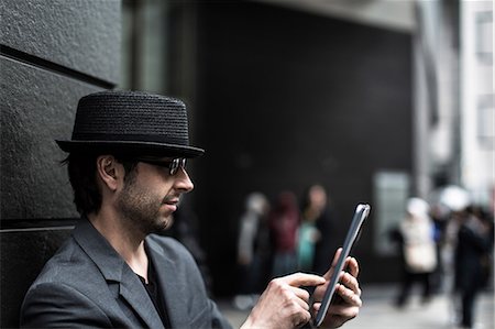 Portrait of man using digital tablet on city street Stock Photo - Premium Royalty-Free, Code: 614-06896565