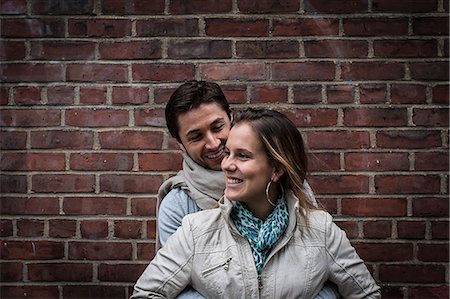 romance couple - Portrait of smiling couple in front of brick wall Foto de stock - Sin royalties Premium, Código: 614-06896561