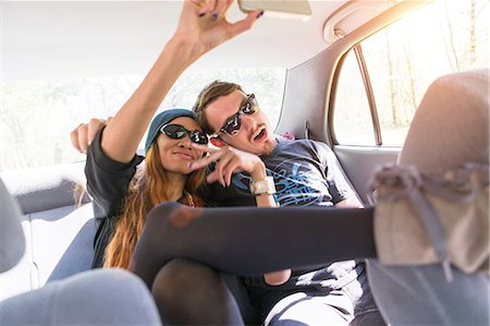 Couple on backseat in car photographing themselves Stock Photo - Premium Royalty-Free, Code: 614-06896597