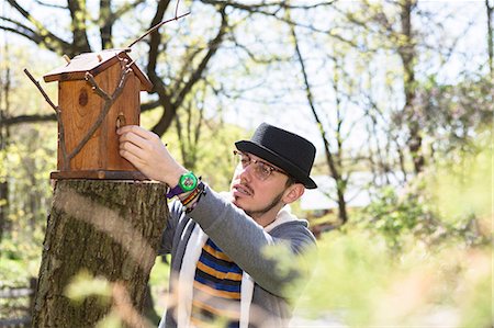 Man looking at bird house Stock Photo - Premium Royalty-Free, Code: 614-06896599