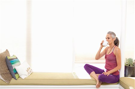 Woman sitting on window seat drinking herbal tea Photographie de stock - Premium Libres de Droits, Code: 614-06896676