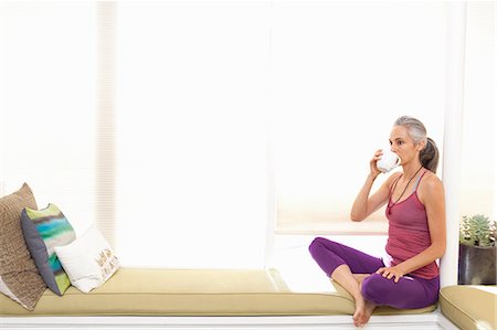 fitness woman healthy food - Woman sitting on window seat drinking herbal tea Stock Photo - Premium Royalty-Free, Code: 614-06896676