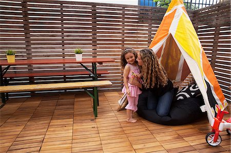 simsearch:614-06896697,k - Mother and daughter by tent on patio Photographie de stock - Premium Libres de Droits, Code: 614-06896696