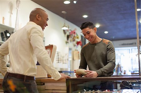 fashion shopping people - Young man buying item from shopkeeper in vintage shop Stock Photo - Premium Royalty-Free, Code: 614-06896765