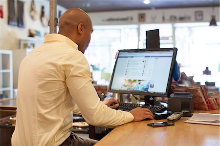 people electronic store - Shopkeeper using computer in vintage shop Stock Photo - Premium Royalty-Free, Code: 614-06896772