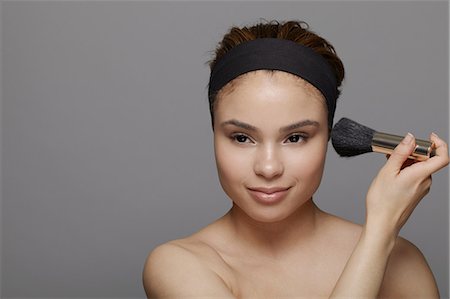 skin woman happy - Young woman using blusher brush Stock Photo - Premium Royalty-Free, Code: 614-06896818