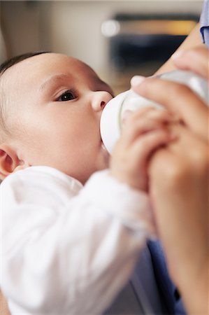 Baby girl drinking bottle of milk Foto de stock - Royalty Free Premium, Número: 614-06896810