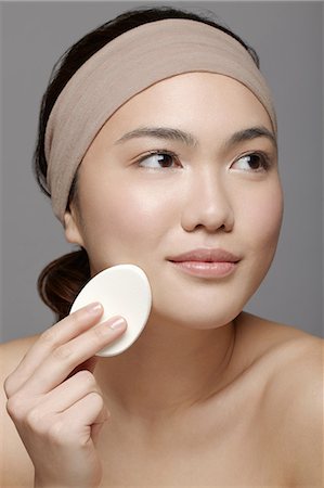 Young woman using make up sponge Foto de stock - Sin royalties Premium, Código: 614-06896823