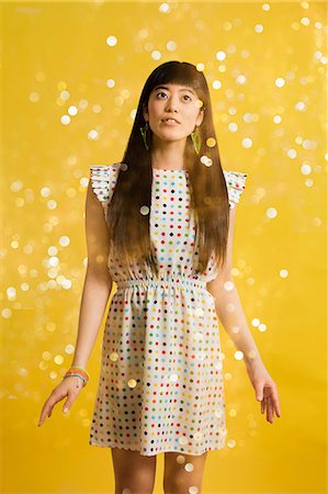 Portrait of young woman wearing spotted dress with glitter Stock Photo - Premium Royalty-Free, Code: 614-06896877