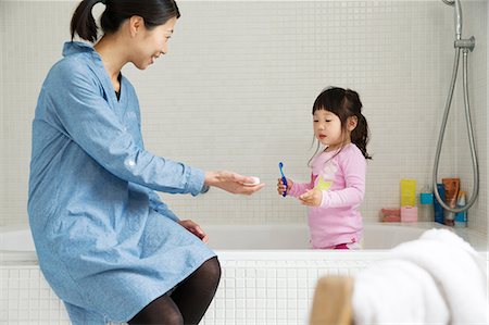 Mother with female toddler standing in bath with tooth brush Stock Photo - Premium Royalty-Free, Code: 614-06896921