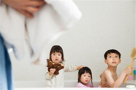 focus on background - Brother and sisters in bath playing Stock Photo - Premium Royalty-Free, Code: 614-06896923