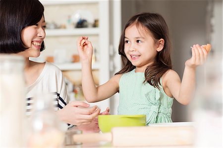 families baking - Mother and young daughter learning to crack eggs Stock Photo - Premium Royalty-Free, Code: 614-06896960