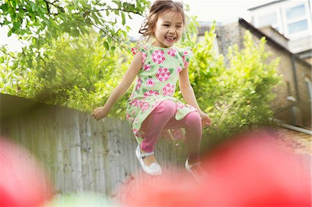 summer gardens - Young girl jumping mid air in garden Stock Photo - Premium Royalty-Free, Code: 614-06896976
