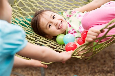 Young girl in hammock with colored balls Stock Photo - Premium Royalty-Free, Code: 614-06896972