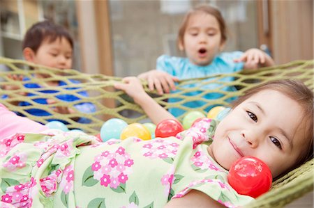 sister with toys - Portrait of young girl in hammock with colored balls Stock Photo - Premium Royalty-Free, Code: 614-06896973
