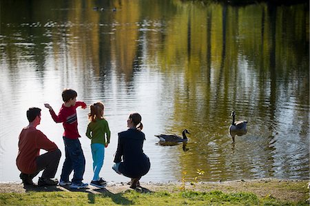 park with pond - Family in park feeding ducks Stock Photo - Premium Royalty-Free, Code: 614-06897024