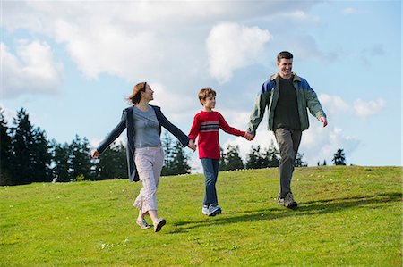 father son walking in field - Parents and son walking hand in hand Stock Photo - Premium Royalty-Free, Code: 614-06897035