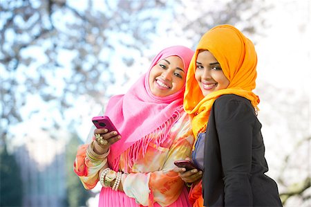 Portrait of two young woman in park with mobile phones Stock Photo - Premium Royalty-Free, Code: 614-06897037