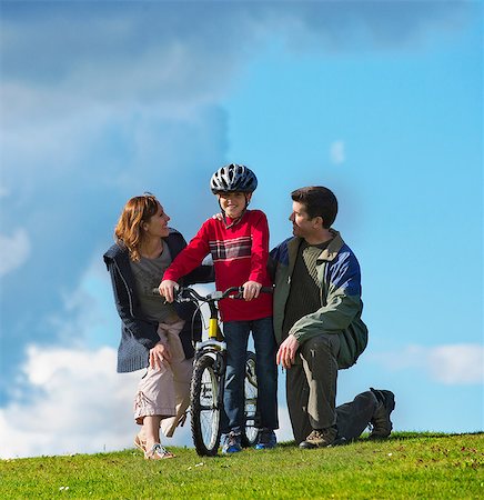 riding (vehicle) - Mother and father encouraging son to ride bicycle Stock Photo - Premium Royalty-Free, Code: 614-06897032