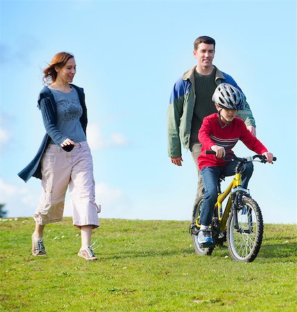family on bikes - Parents watching son riding bicycle Photographie de stock - Premium Libres de Droits, Code: 614-06897033