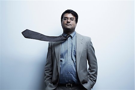 Studio portrait of businessman with flyaway tie Stock Photo - Premium Royalty-Free, Code: 614-06897209