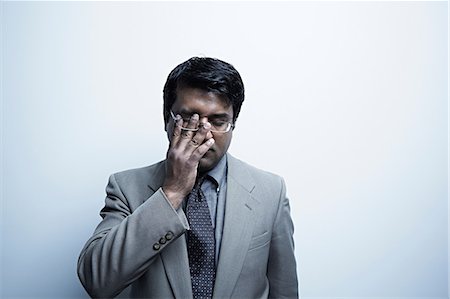 pressure - Studio portrait of businessman rubbing his eye Photographie de stock - Premium Libres de Droits, Code: 614-06897200