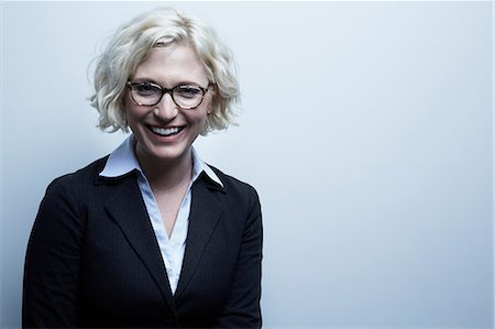 portrait, frontal - Studio portrait of blond businesswoman smiling Stock Photo - Premium Royalty-Free, Code: 614-06897244