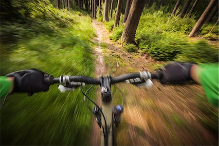 simsearch:614-06897290,k - Mountain biker speeding down forest path Foto de stock - Sin royalties Premium, Código: 614-06897295