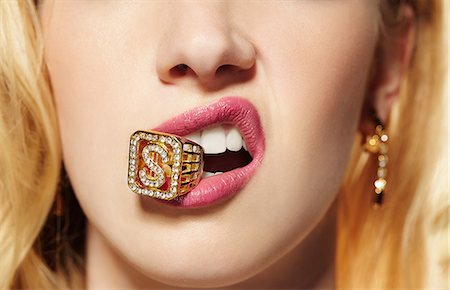 Close up of young woman with diamond ring in her mouth Stock Photo - Premium Royalty-Free, Code: 614-06897312