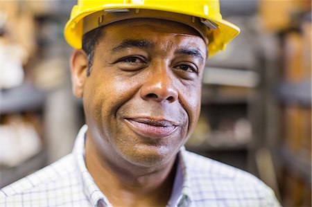 serving - Close up portrait of man in stockroom wearing hard hat Stock Photo - Premium Royalty-Free, Code: 614-06897343