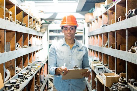 sombrero - Young woman in warehouse with clipboard Foto de stock - Sin royalties Premium, Código: 614-06897358