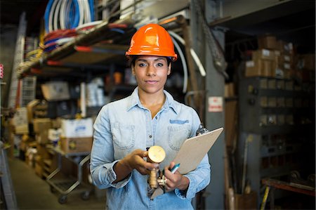 Portrait of young woman in warehouse with clipboard Stock Photo - Premium Royalty-Free, Code: 614-06897359