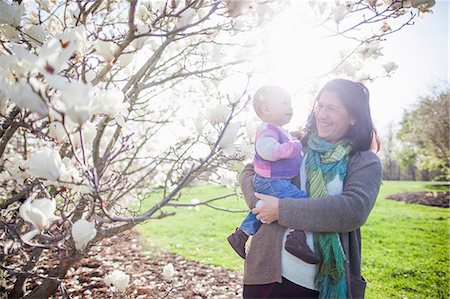 petit-enfant - Portrait of baby girl and grandmother next to magnolia blossom Photographie de stock - Premium Libres de Droits, Code: 614-06897399