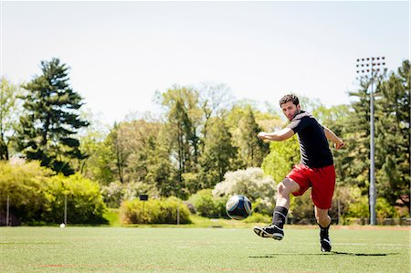 Soccer player running and kicking ball Photographie de stock - Premium Libres de Droits, Code: 614-06897435