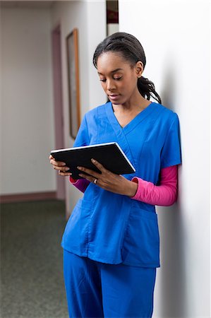 scrutinio - Nurse using digital tablet in hospital corridor Fotografie stock - Premium Royalty-Free, Codice: 614-06897455