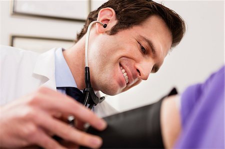 doctors studying people - Mid adult doctor using stethoscope and blood pressure cuff on patient, close up Stock Photo - Premium Royalty-Free, Code: 614-06897479