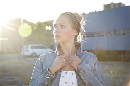 funky cool women - Portrait of woman holding jacket collar in industrial district Stock Photo - Premium Royalty-Free, Code: 614-06897536