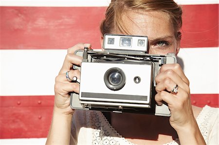 Woman taking photograph using vintage camera Stock Photo - Premium Royalty-Free, Code: 614-06897552