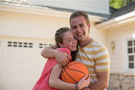 Brother with arm around sister holding basketball Photographie de stock - Premium Libres de Droits, Code: 614-06897601