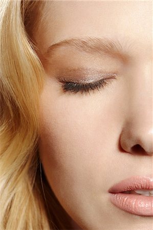 Close-up portrait of blonde woman with eyes closed Stock Photo - Premium Royalty-Free, Code: 614-06897685