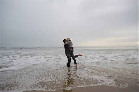 simsearch:614-06897719,k - Mature couple embracing on beach Fotografie stock - Premium Royalty-Free, Codice: 614-06897720