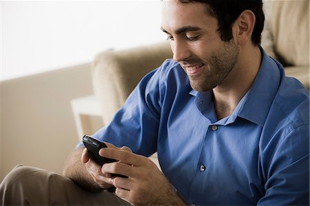 Young man using cell phone Stock Photo - Premium Royalty-Free, Code: 614-06897755