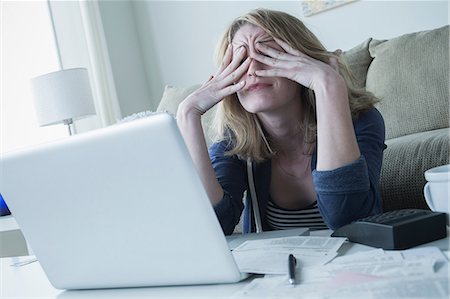 sad women paying bills - Stressed young woman rubbing eyes Stock Photo - Premium Royalty-Free, Code: 614-06897771