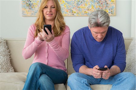 Mature couple using cell phones Stock Photo - Premium Royalty-Free, Code: 614-06897818