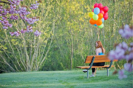 Teenage girl sitting on park bench with balloons Stockbilder - Premium RF Lizenzfrei, Bildnummer: 614-06897838