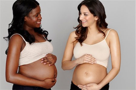 pregnant crop tops - Two pregnant women touching stomachs Stock Photo - Premium Royalty-Free, Code: 614-06897862