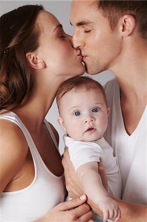 Mother and father kissing, with baby daughter Photographie de stock - Premium Libres de Droits, Code: 614-06897879